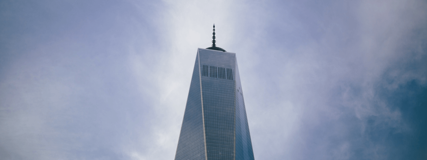 Looking up to the top of One World Trade Center on a partly cloudy day