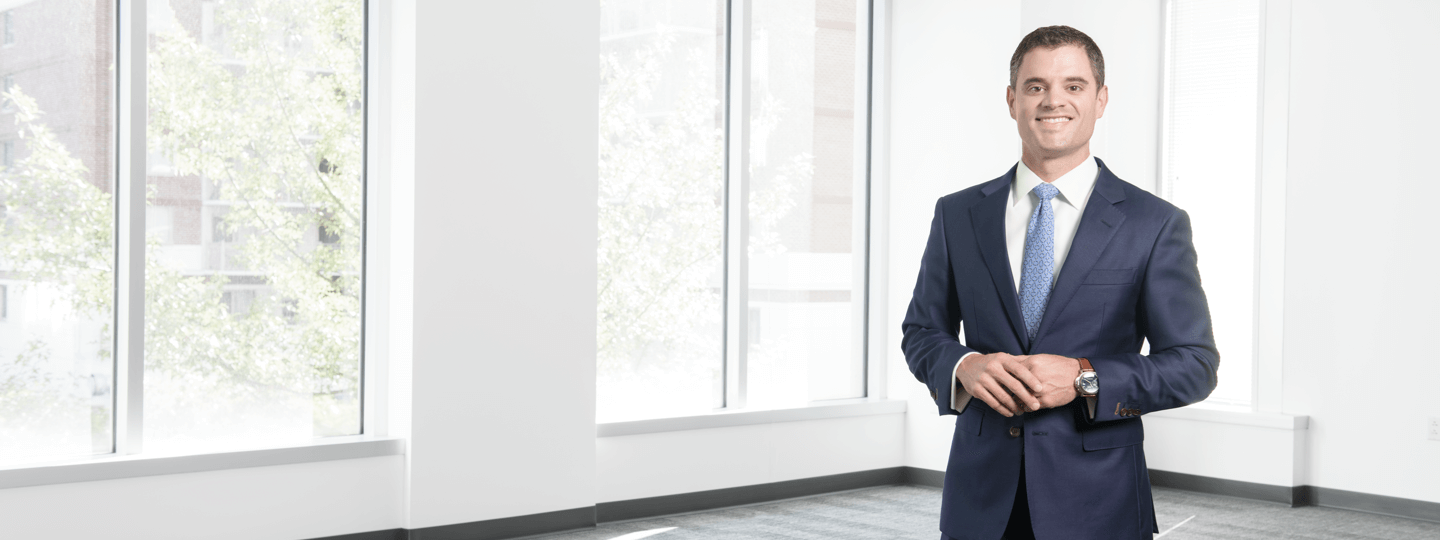 A man in a suite smiling inside an empty room