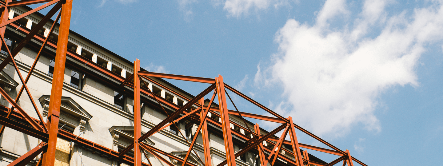 Steel scaffolding lines the outside of an old building