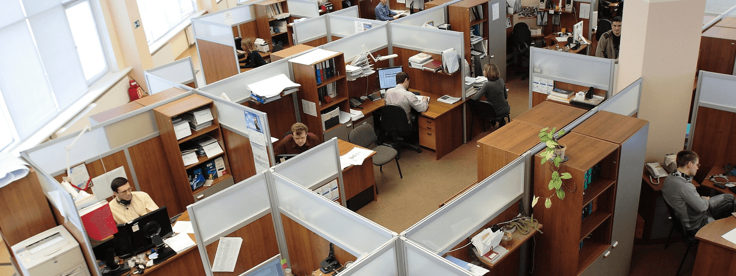 A top down view of an office with employees working in cubicles