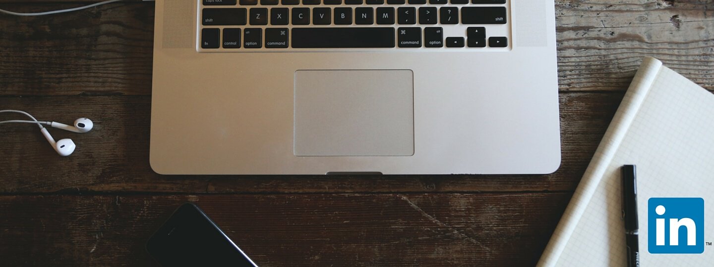 A laptop on a table with the Linkedin logo in the corner