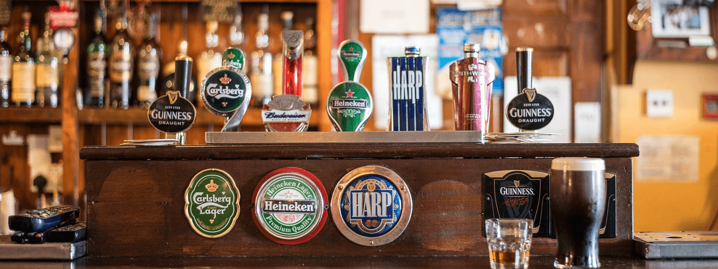 A bar with several various beer brands on tap