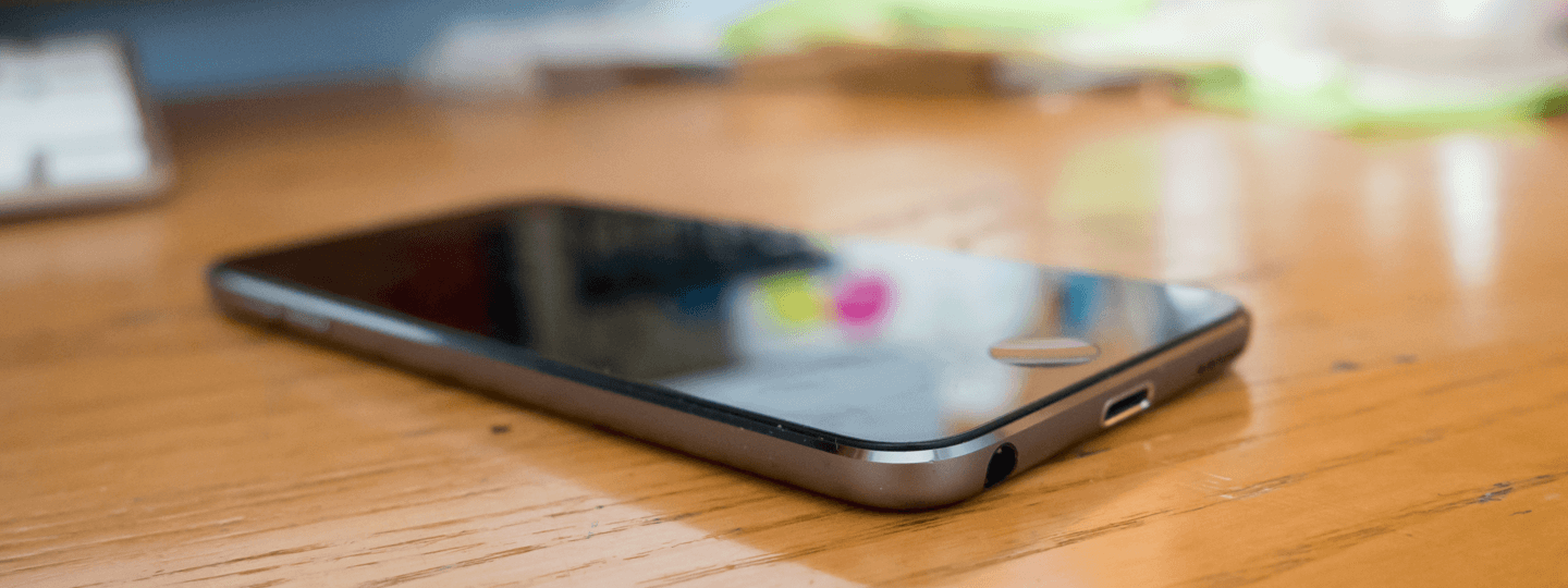 A black iPhone sitting on a table