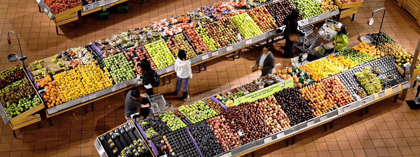 A top down view of fruit and vegetable stands in a grocery store