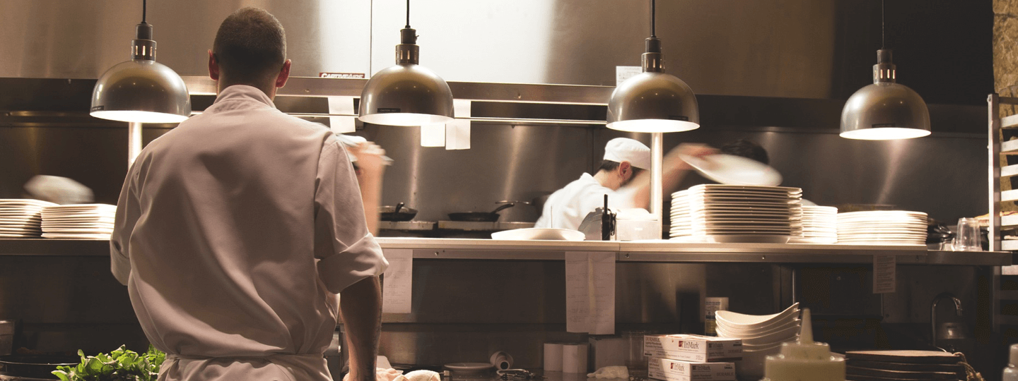 Several cooks working in a resteraunt kitchen