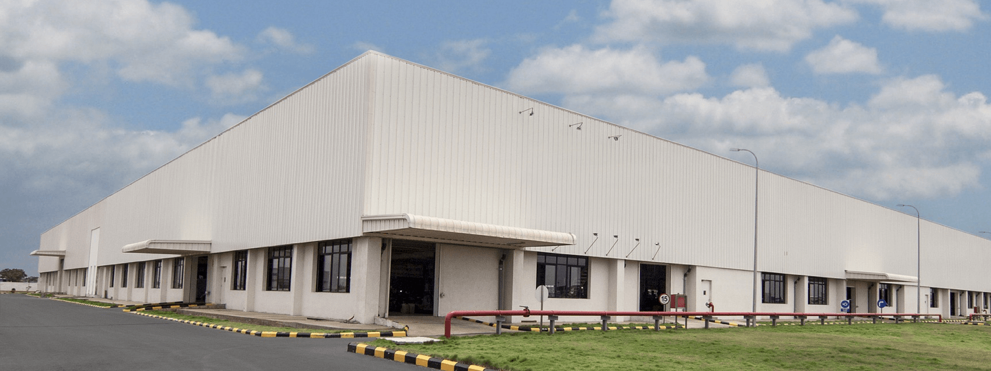 Exterior of a large warehouse with a green front lawn