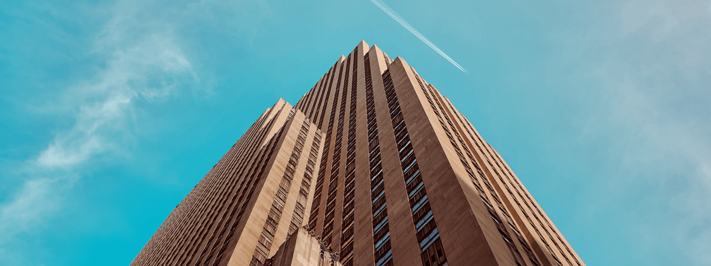 Looking up a large stone and glass high rise