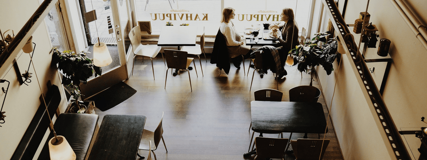 Two females talking and eating at a cafe