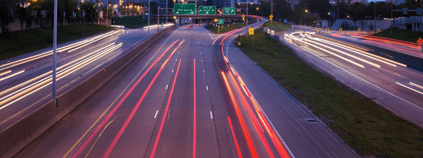 Streaking car lights on a freeway adjacent to a city