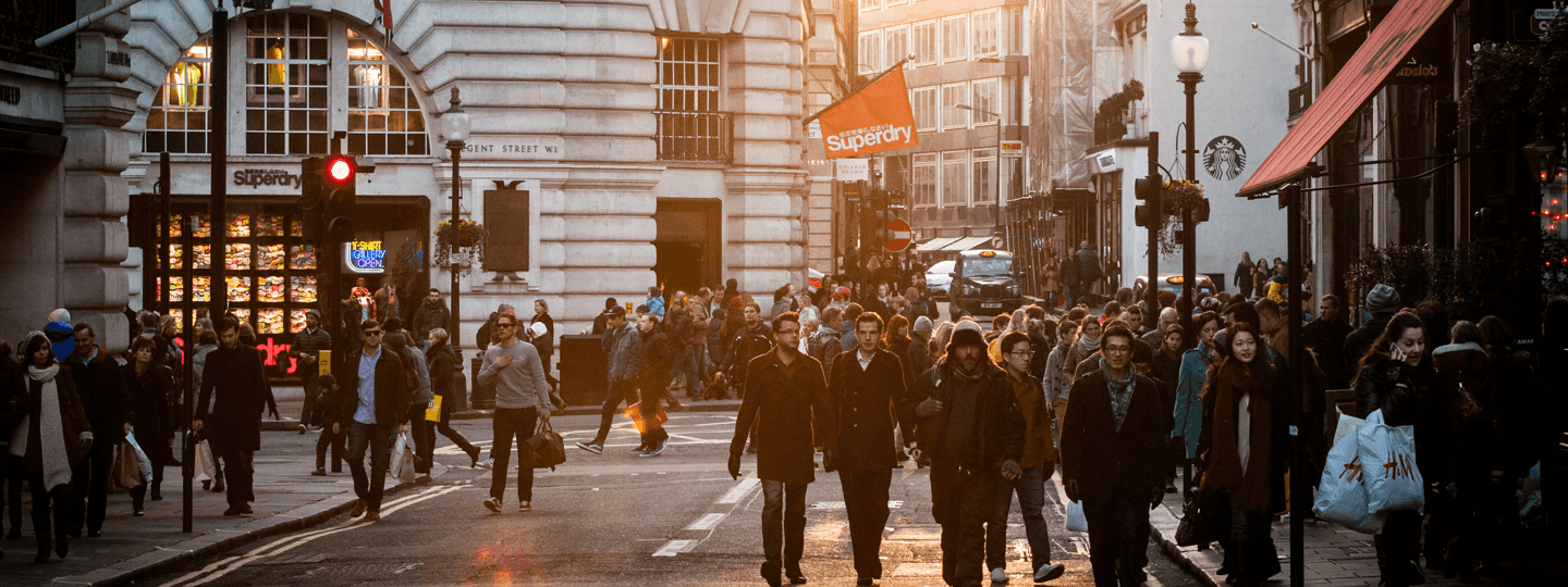 A very busy street intersection with many people in a retail district