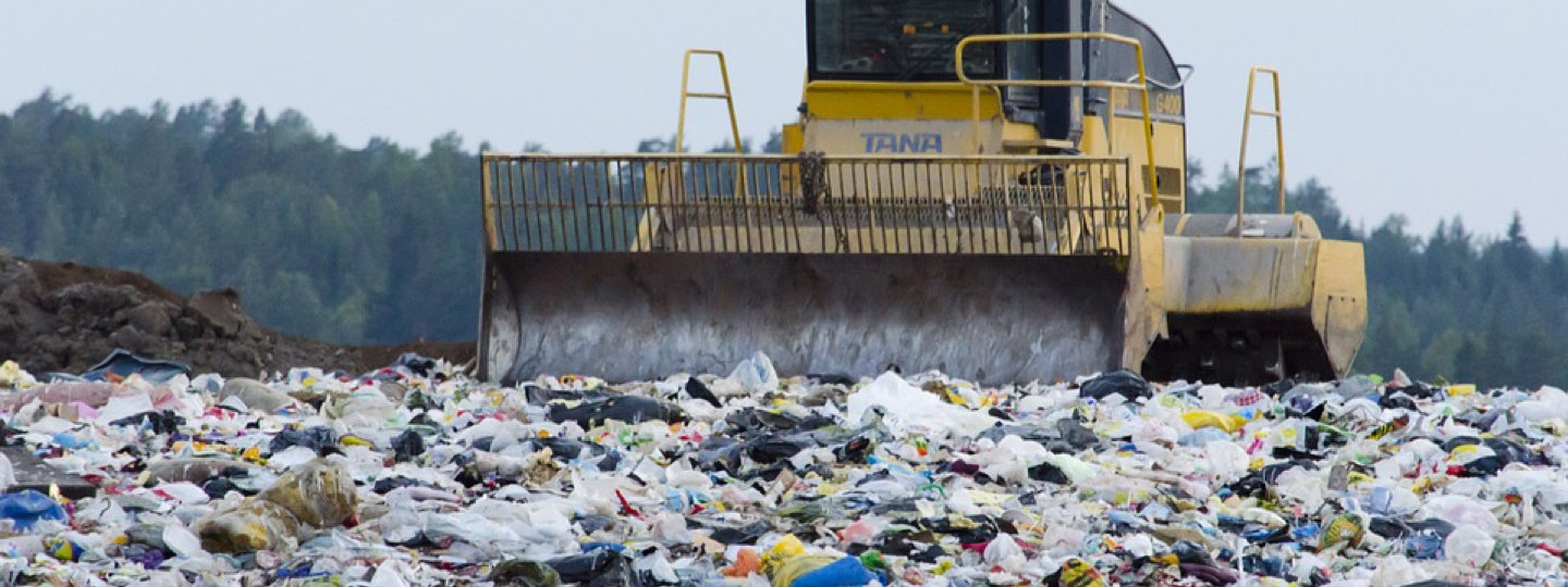 A large compactor working in a landfill