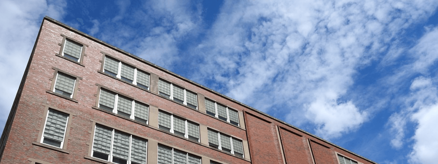 Looking up to the top corner of a brick dormitory