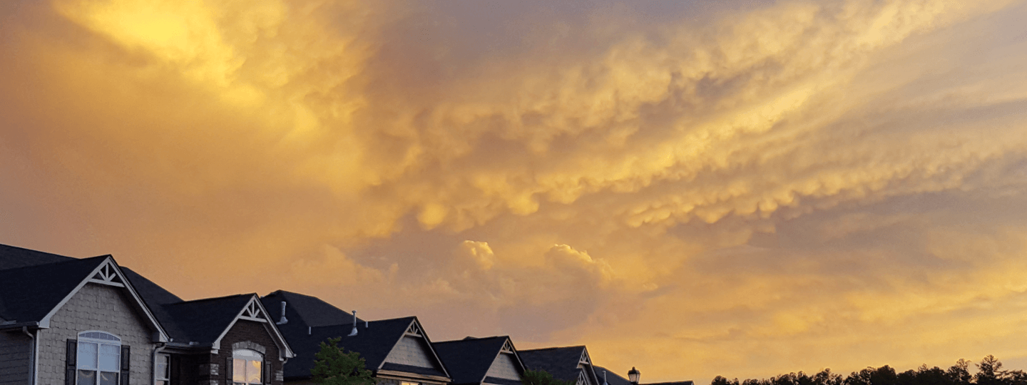 Yellow clouds at sunset over residential homes