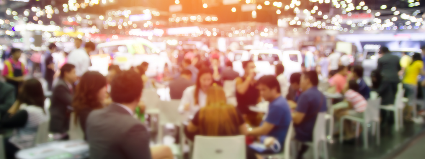 A blurry view of people sitting at tables with vibrant lighting