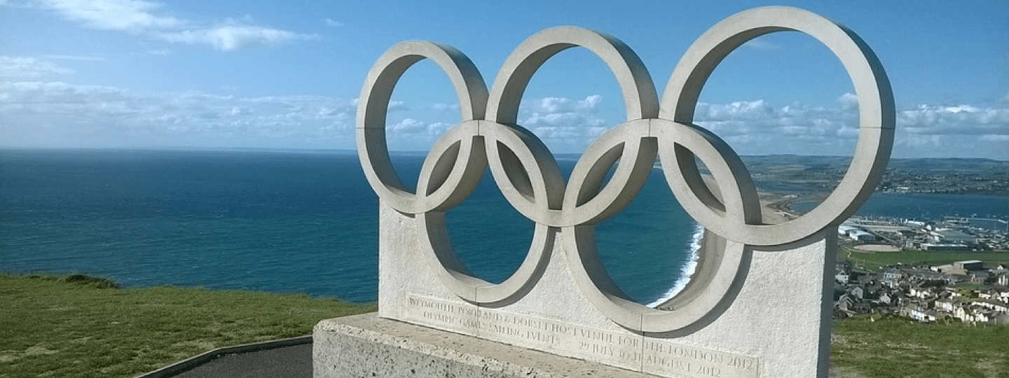 The olympic rings on a hillside overlooking the ocean