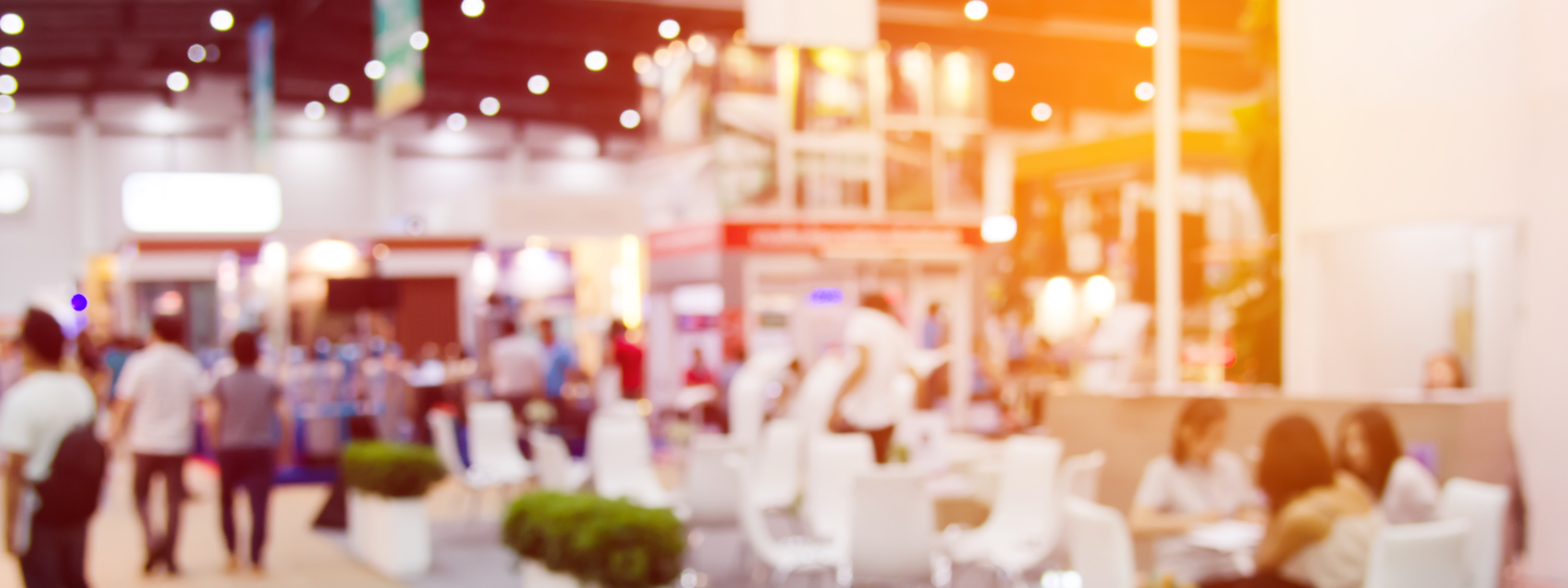 An out of focus view of a conference room with various booths and tables