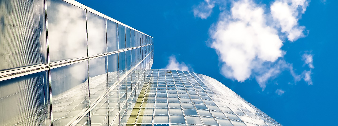 High rise building facades against a cloudy blue sky