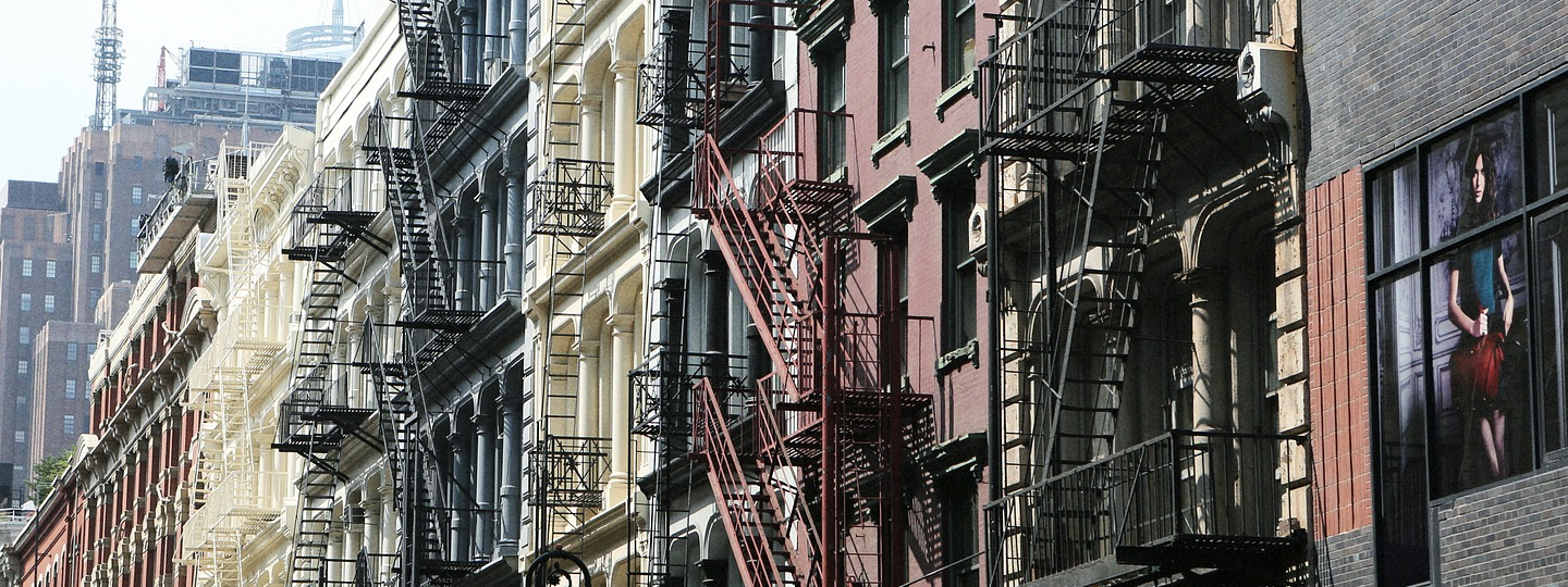 Tall buildings with fire escapes in a large city