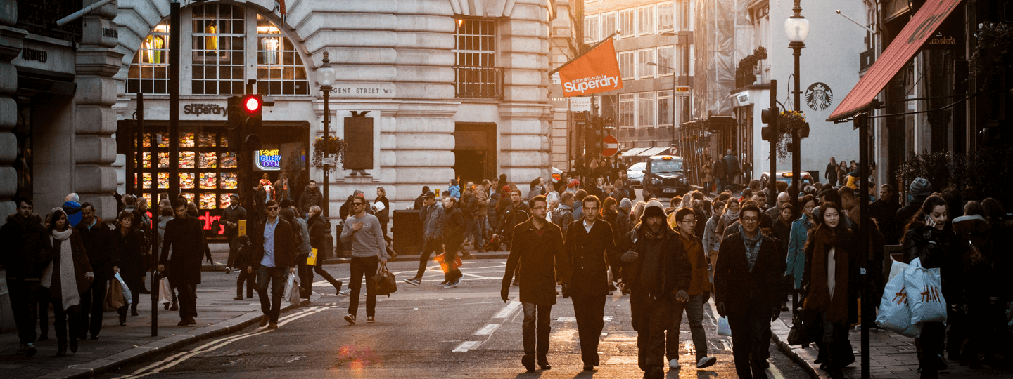 A very busy street intersection with many people in a retail district