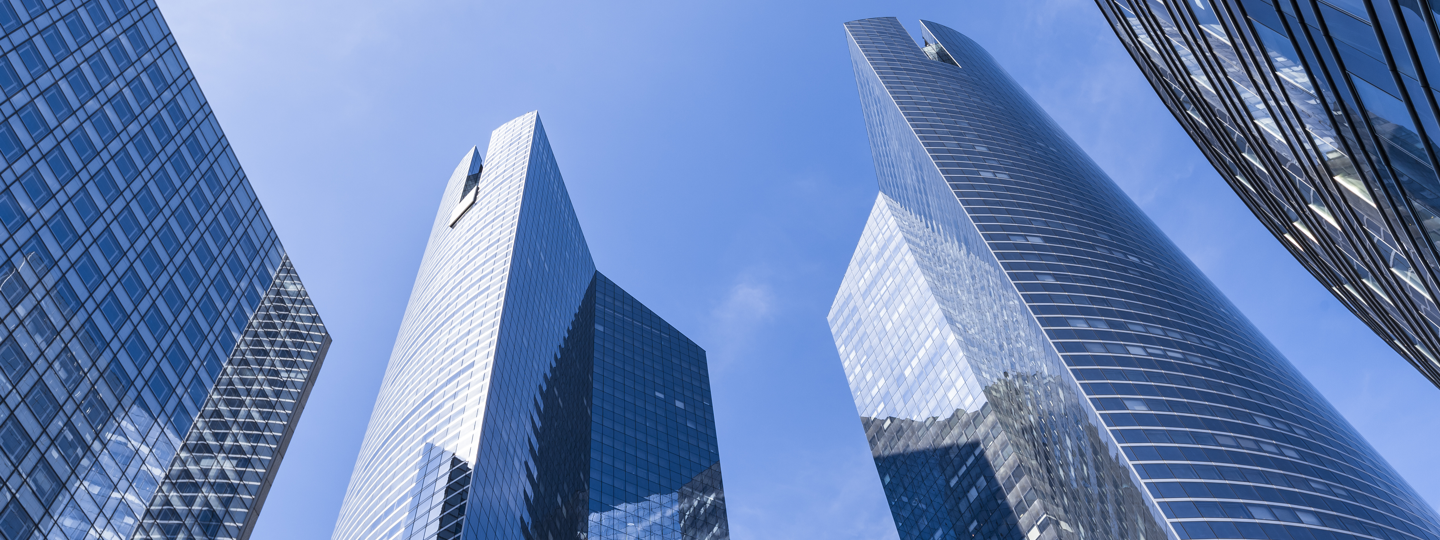 Looking up towards the tops of several large glass skyscrapers