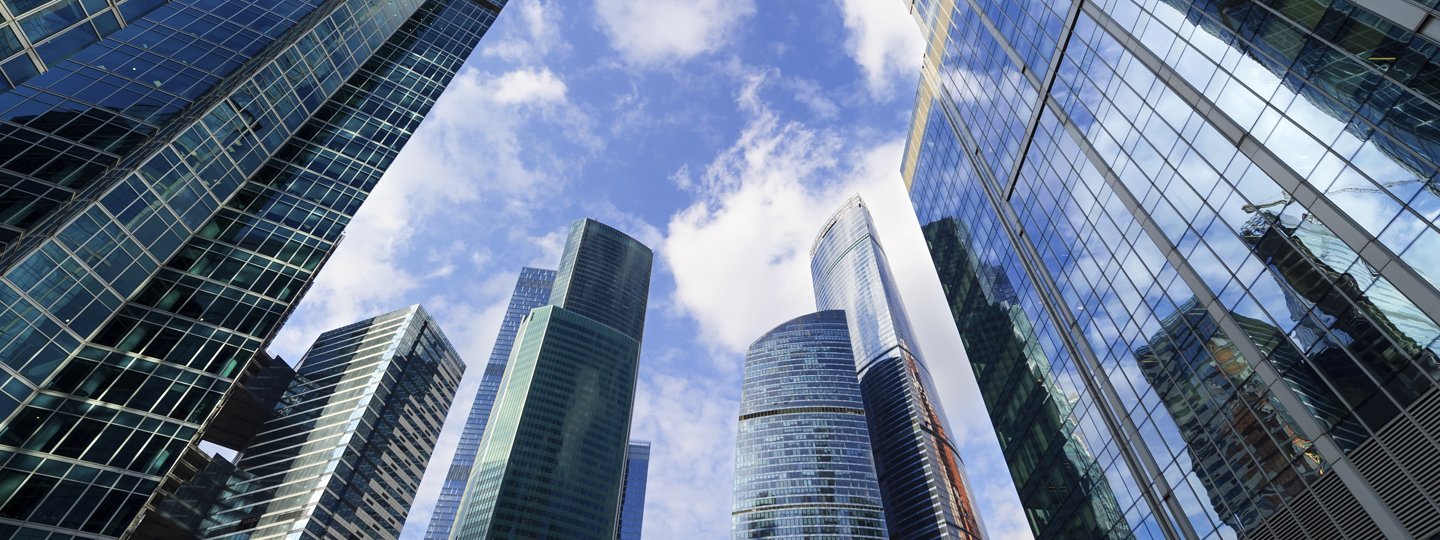 A view of multiple skyscrapers against a cloudy blue sky