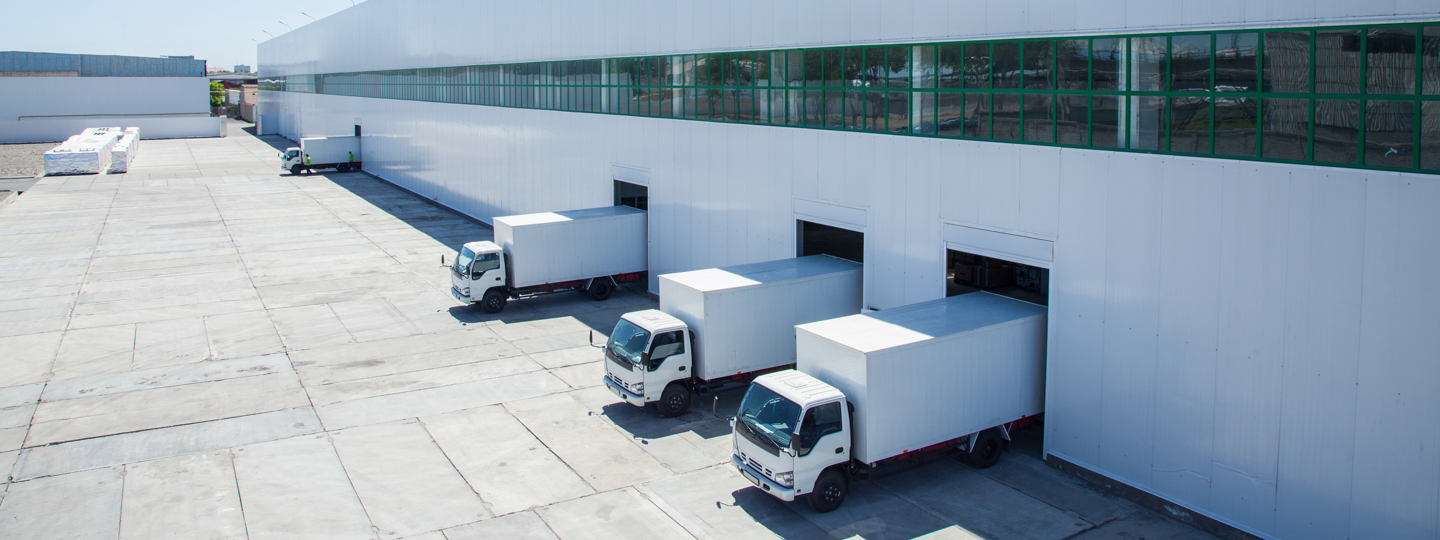 Four trucks in loading docks at a very large warehouse