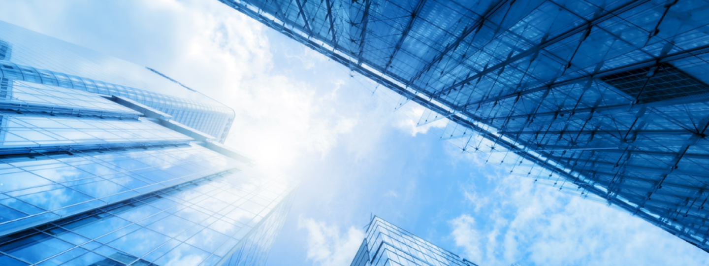 Looking up to the sky between large office buildings