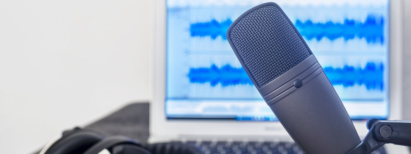 A closeup of a microphone in front of a computer screen