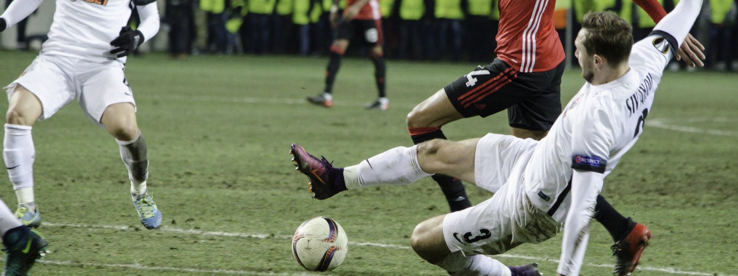 A soccer player slides in for the ball during a match