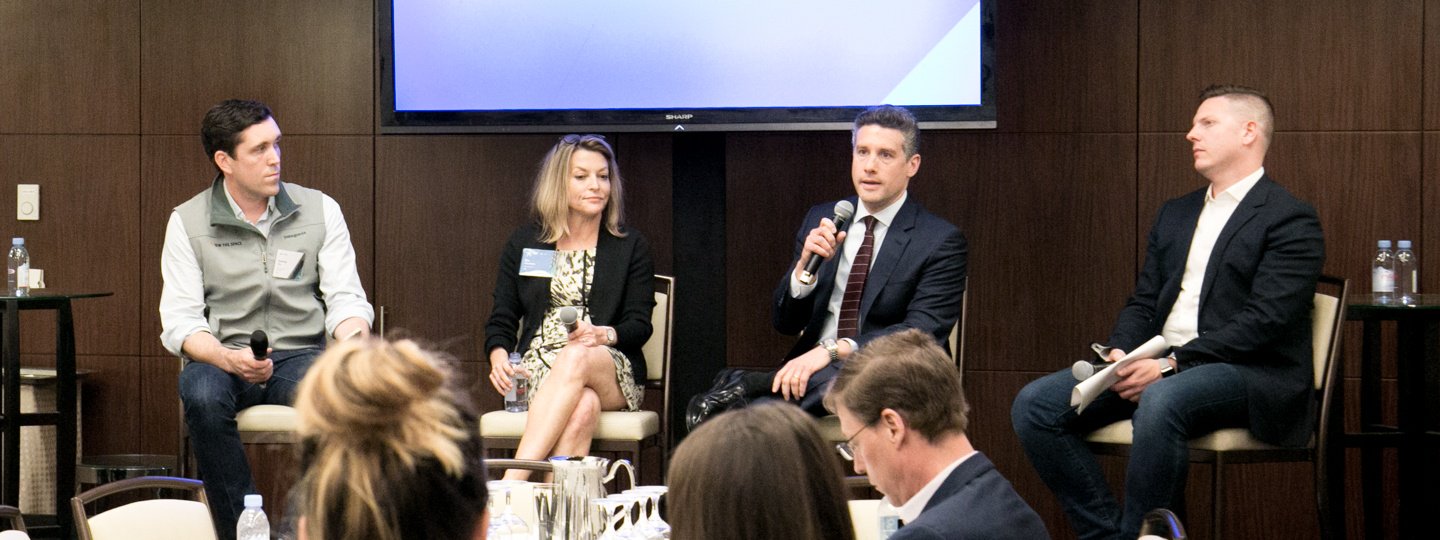 Four panelists answering questions in a conference room