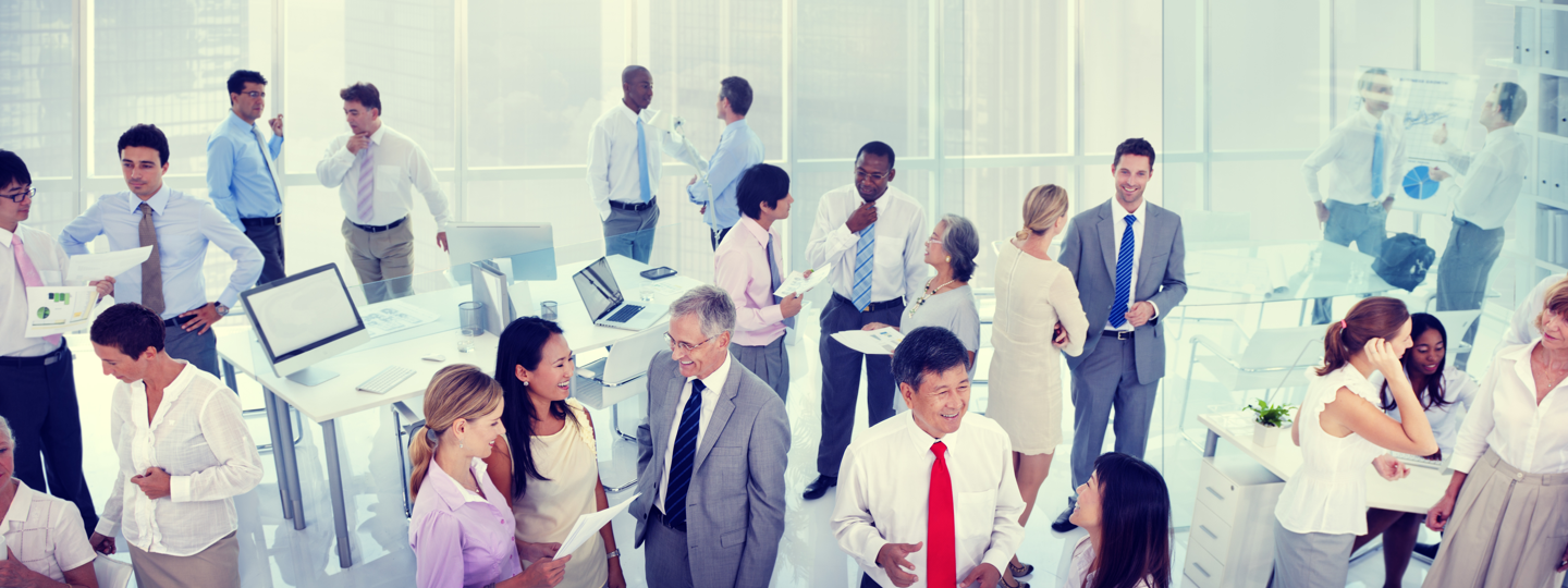 A large group of professionals mingling inside an office building