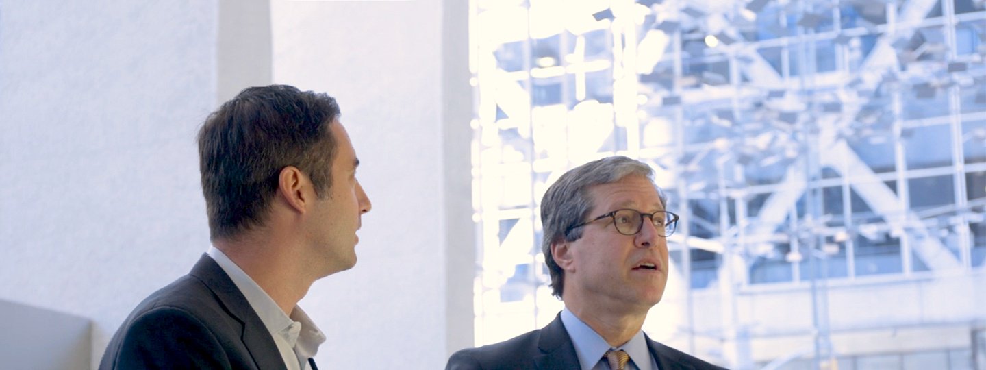 Two men in suites inside an office building