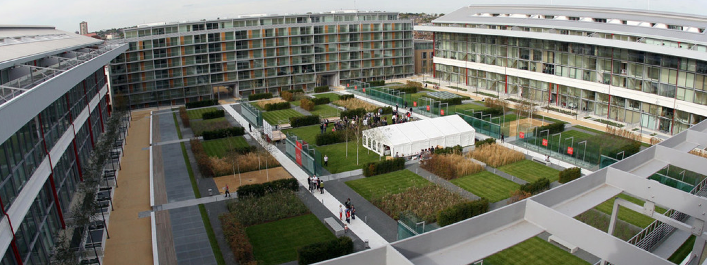 A large central building courtyard with patches of grass and a large white tent