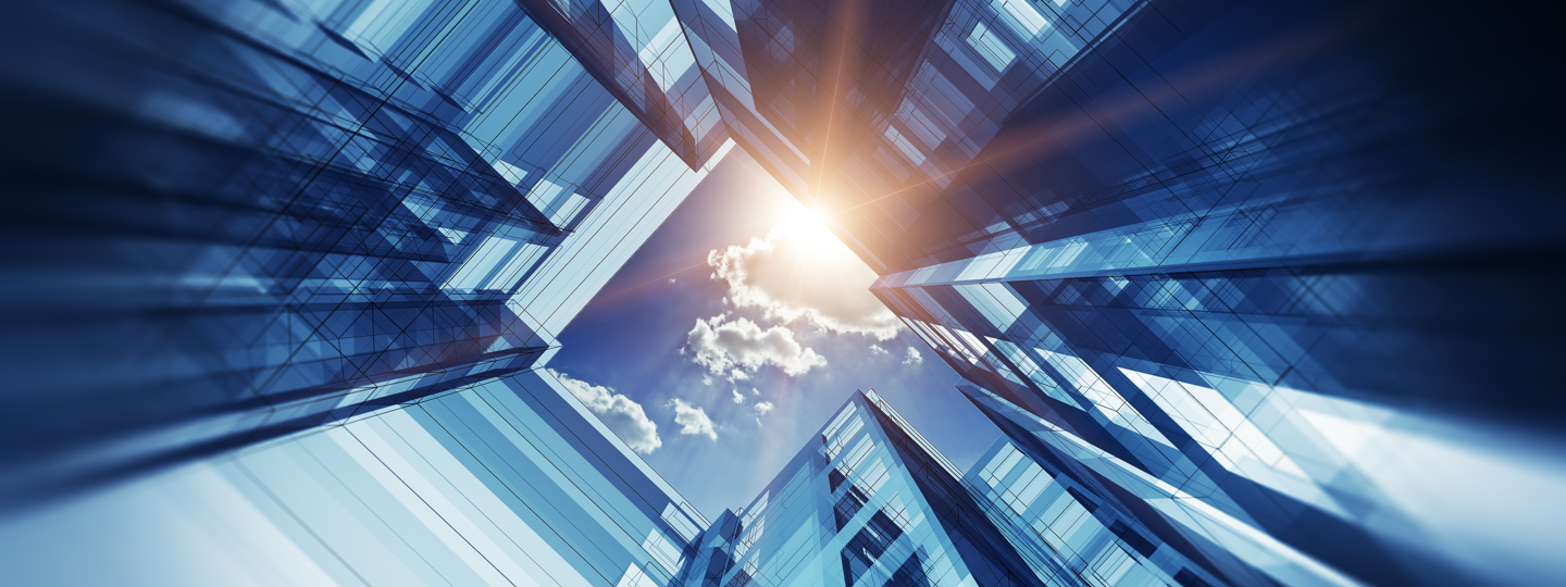 Looking up through high rise buildings to a partly cloudy sky