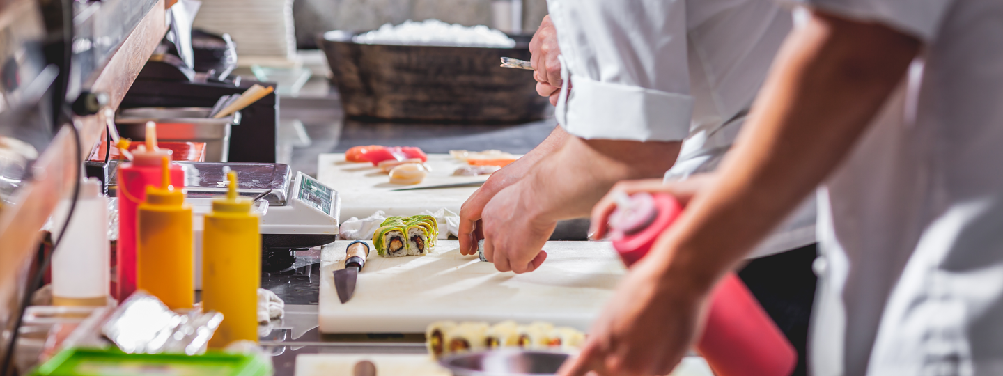 Food workers preparing sushi in a restaurant kitchen