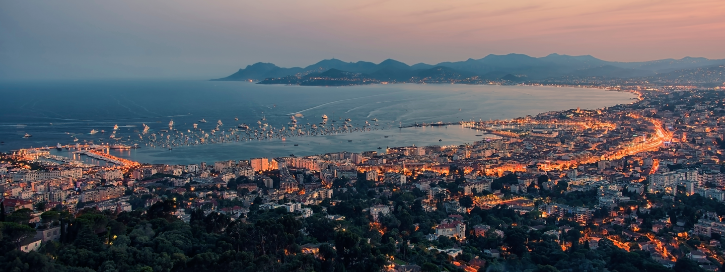 Aerial view of a dense city at dusk on an ocean bay