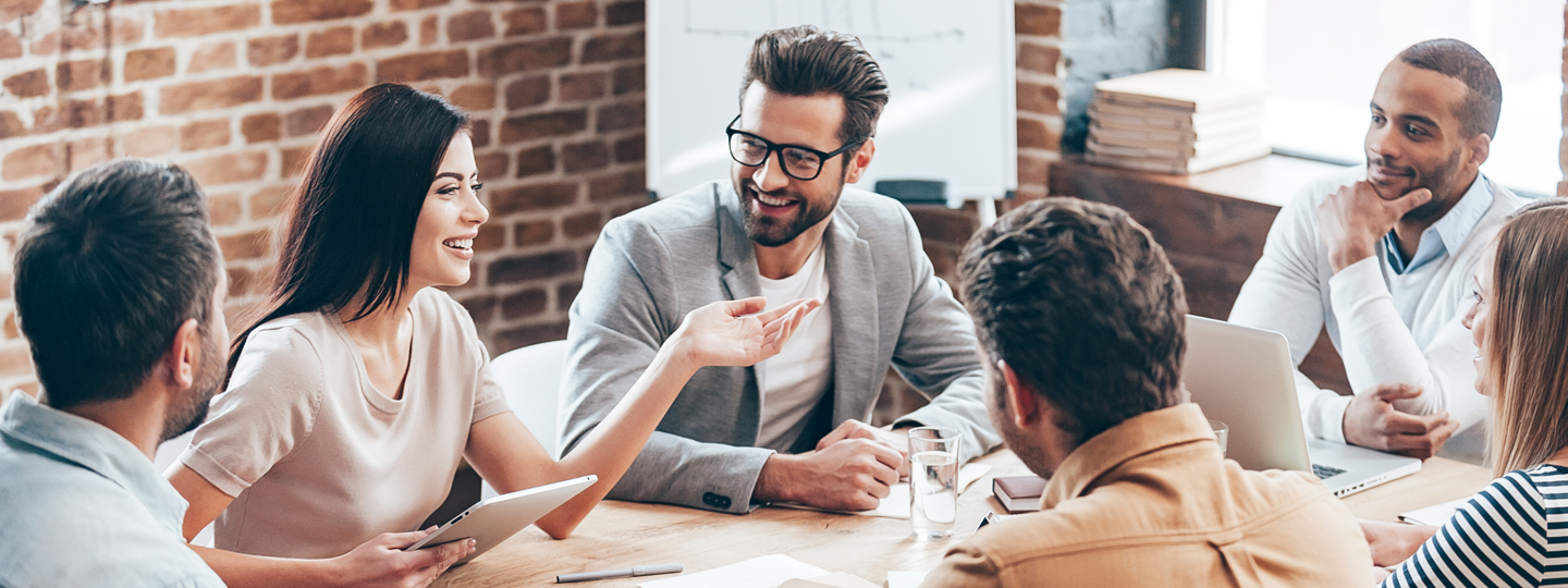 6 young professionals laughing around a table