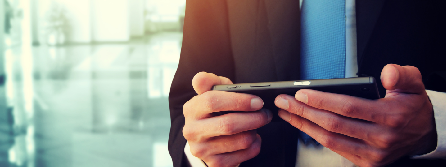 A closeup of a man in a suit looking at his phone