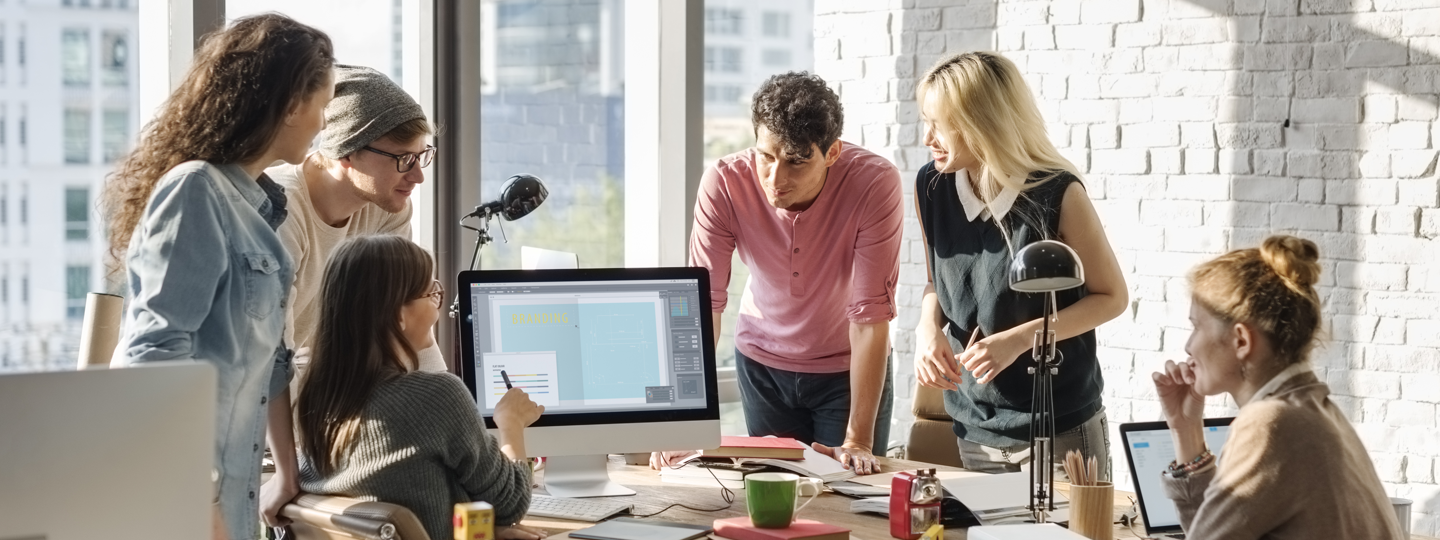 A group of employees collaborating around a computer