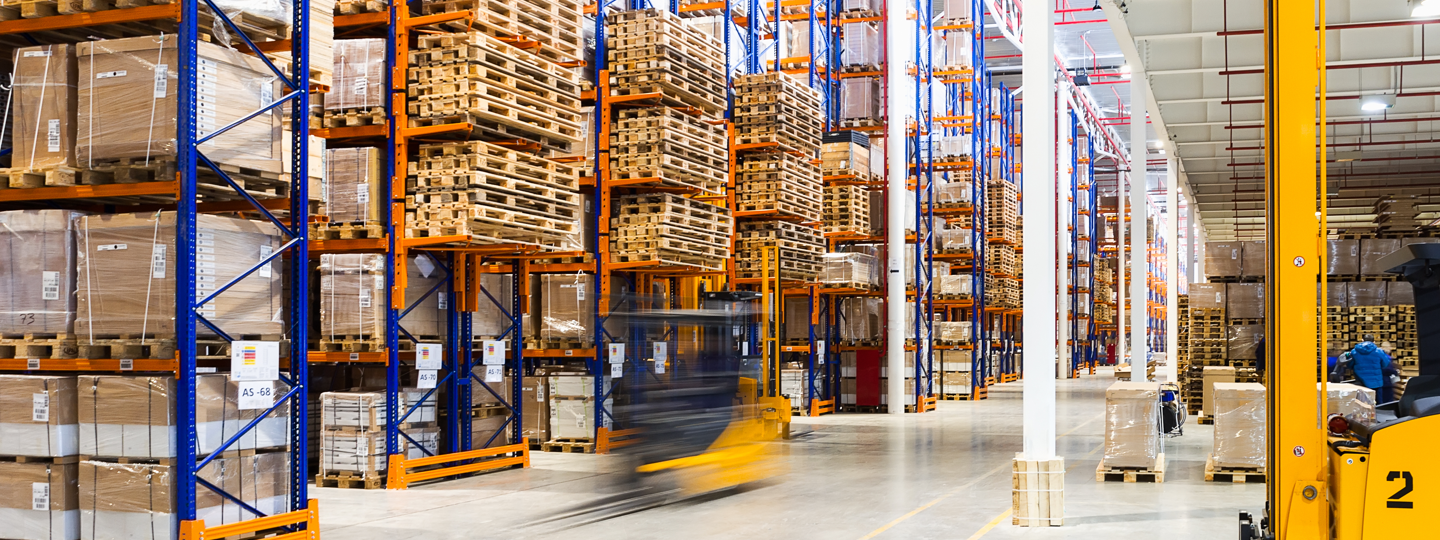 Inside a large warehouse full of pallets and boxes on racks