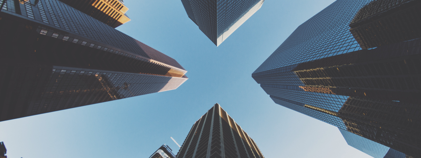 Looking up between four very tall office buildings